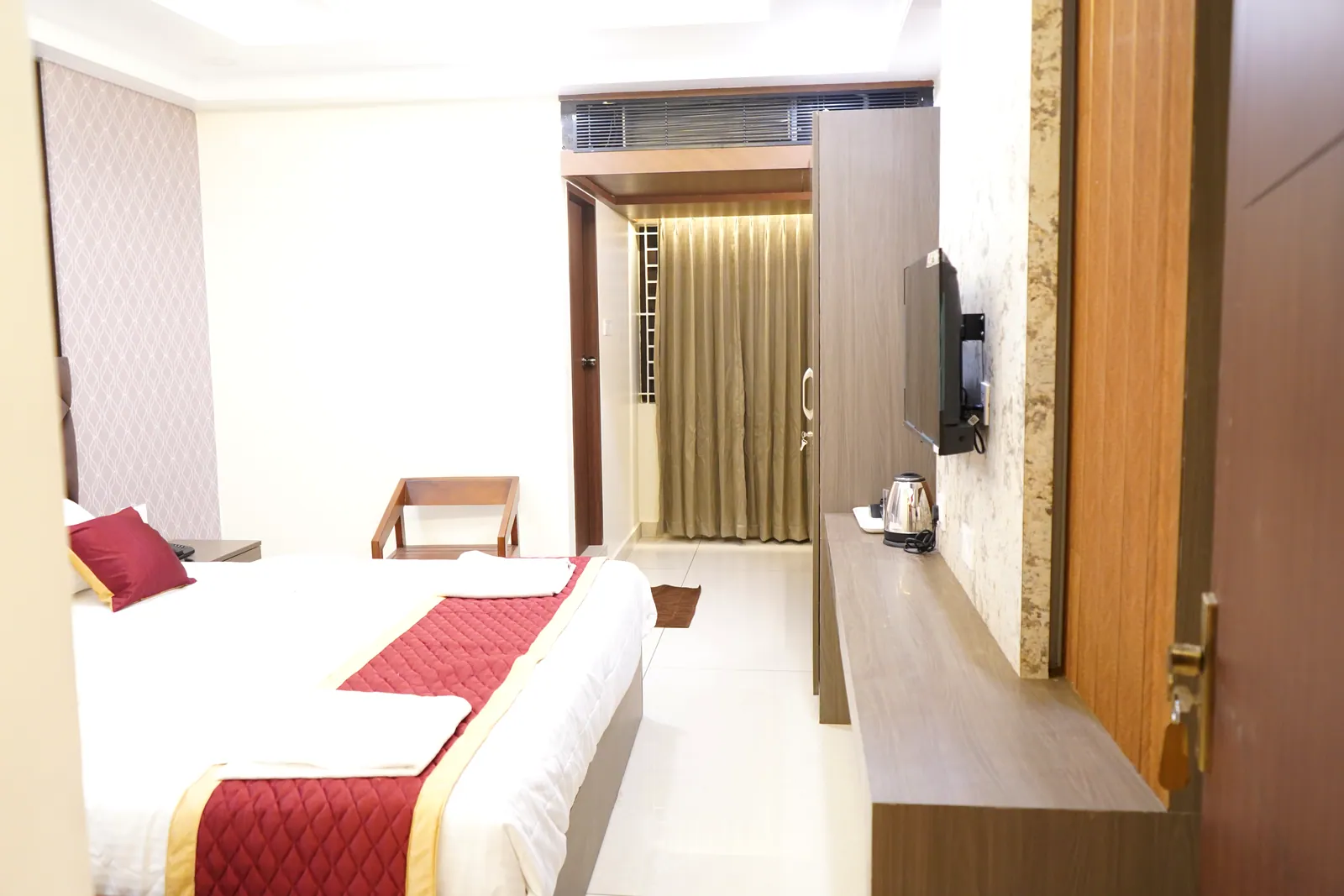 Deluxe room with a bed, television and an electric kettle