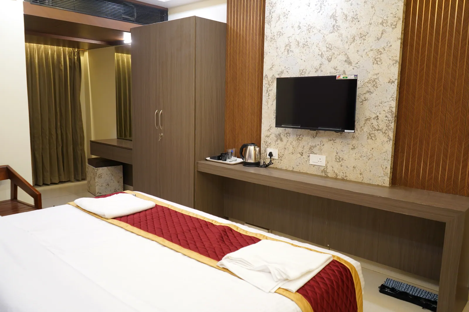 Deluxe room with a wardrobe, wall-mounted television and a work and dressing counter