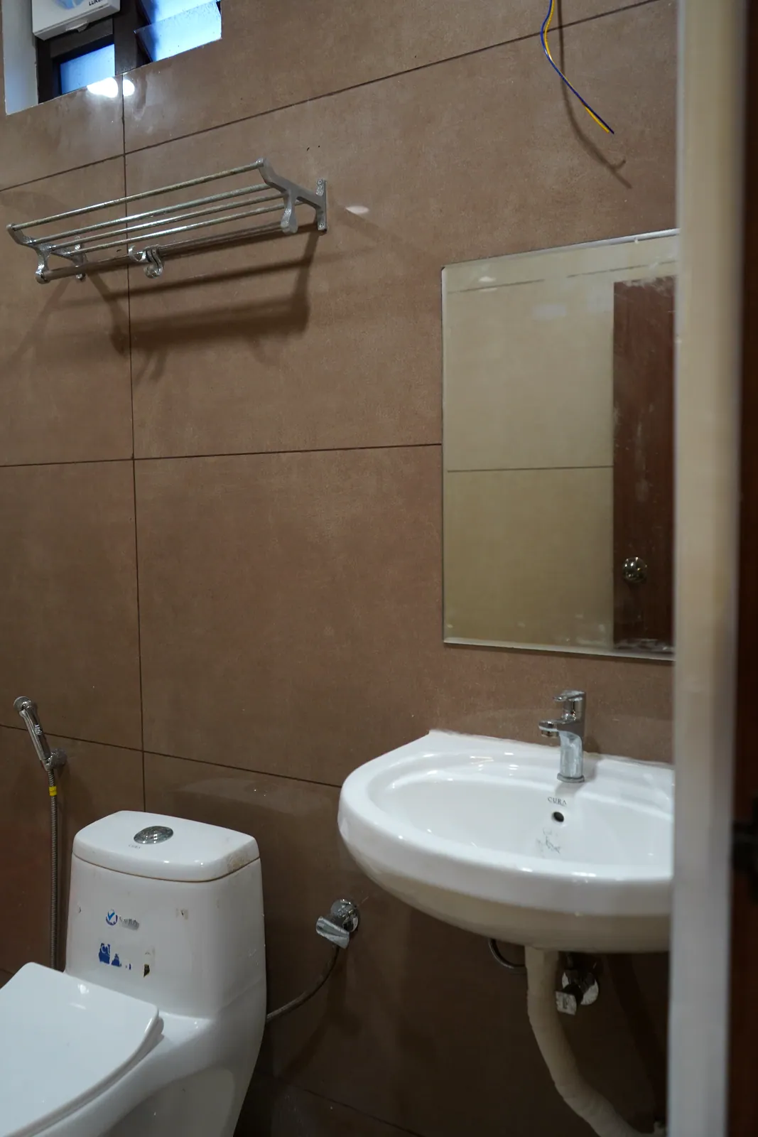 Super Deluxe room bathroom with a wash basin, toilet and mirror