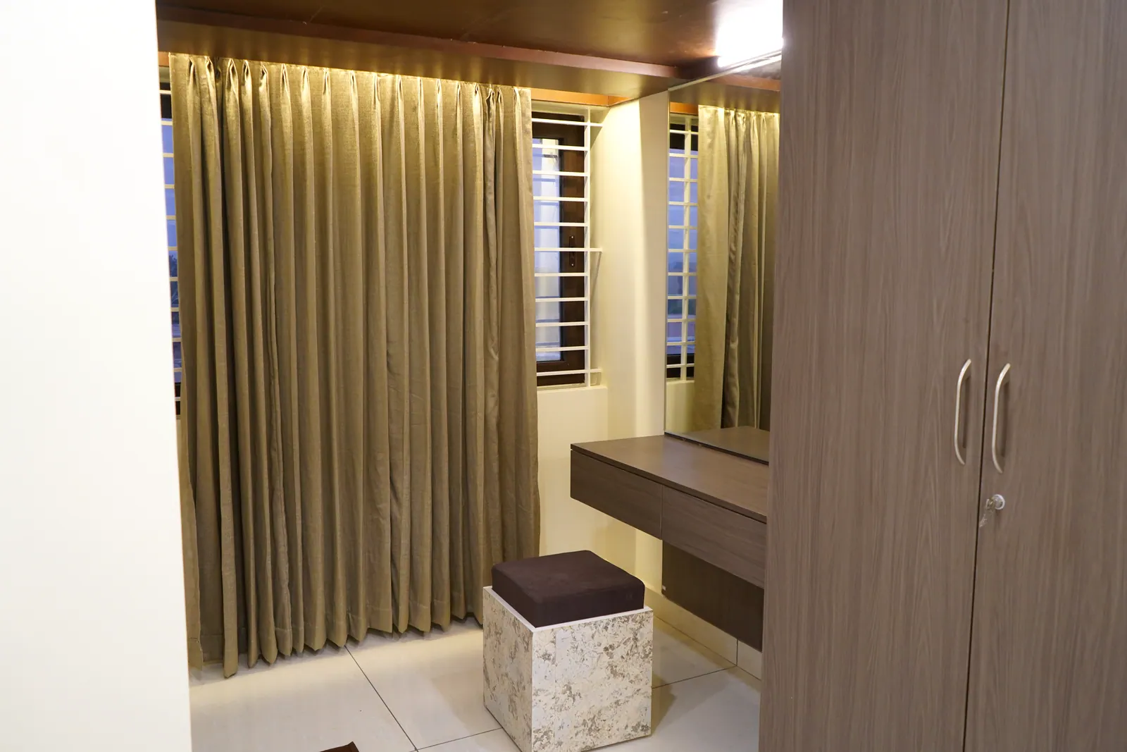 Super Deluxe room corner with curtains, a dressing stool and a wardrobe